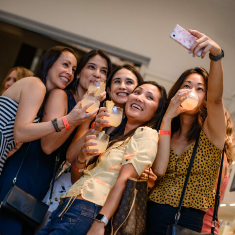 Group of girls taking a selfie with their cocktails at our shopping event